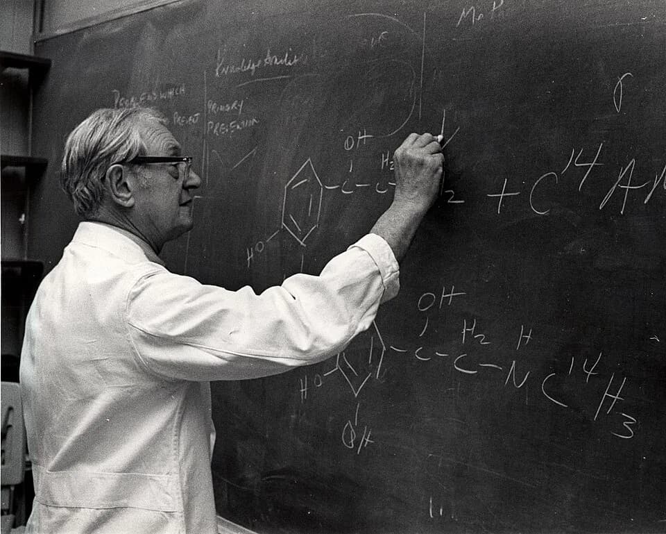 Julius Axelrod - Dr. Julius Axelrod checking a student's work on the chemistry of catecholamine reactions in nerve cells.