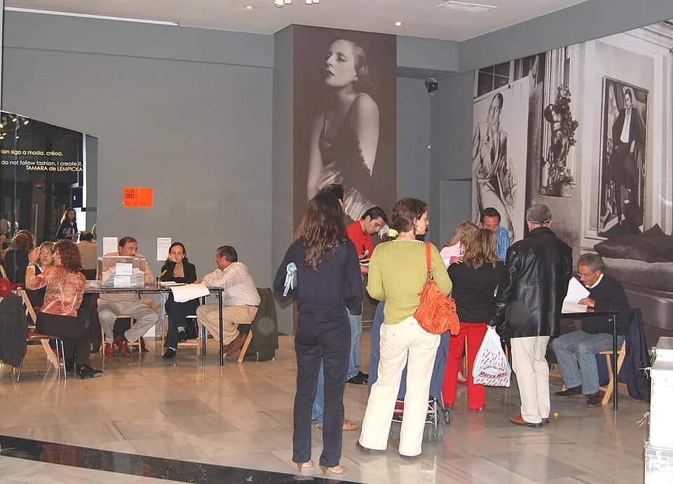 Tamara de Lempicka - Cidadãos votam nas eleições municipais em Vigo, Galiza. No fundo um retrato da pintora Tamara de Lempicka.