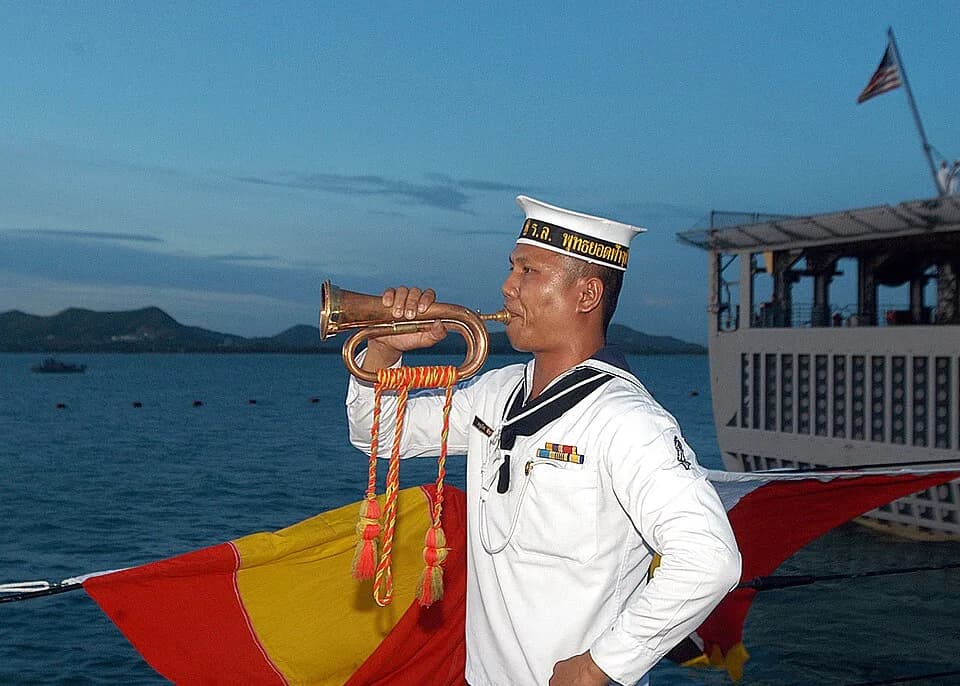 Phutthayotfa Chulalok - Sattahip, Thailand (June 21, 2005) - A Royal Thai Navy bugler aboard HTMS Phutthayotfa Chulalok sounds a call marking evening colors aboard his ship was the colors detail, righ