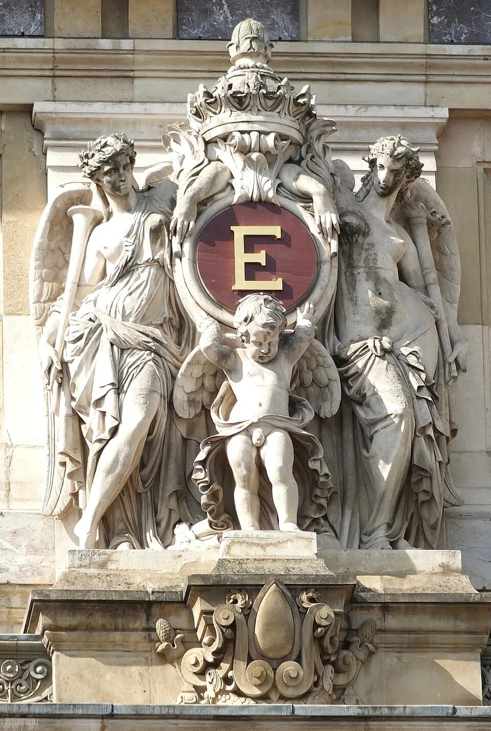 Eugénie de Montijo - Un des cinq groupes sculptés encadrant le "E" de l'impératrice Eugénie, bandeau supérieur de la façade principale de l'opéra Garnier, Paris (9e arrondissement).