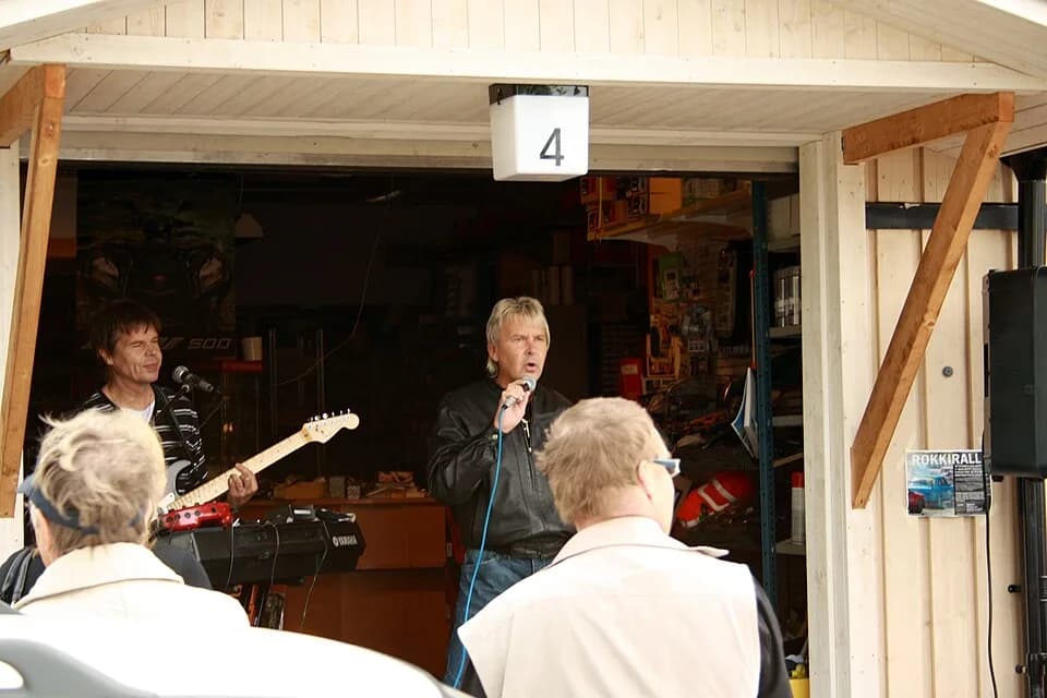 Matti Nykänen - Matti Nykänen singing and joking with his guitarist during a performance held at a car repair parts shop in Kirkkonummi, on the 19th of June 2010.