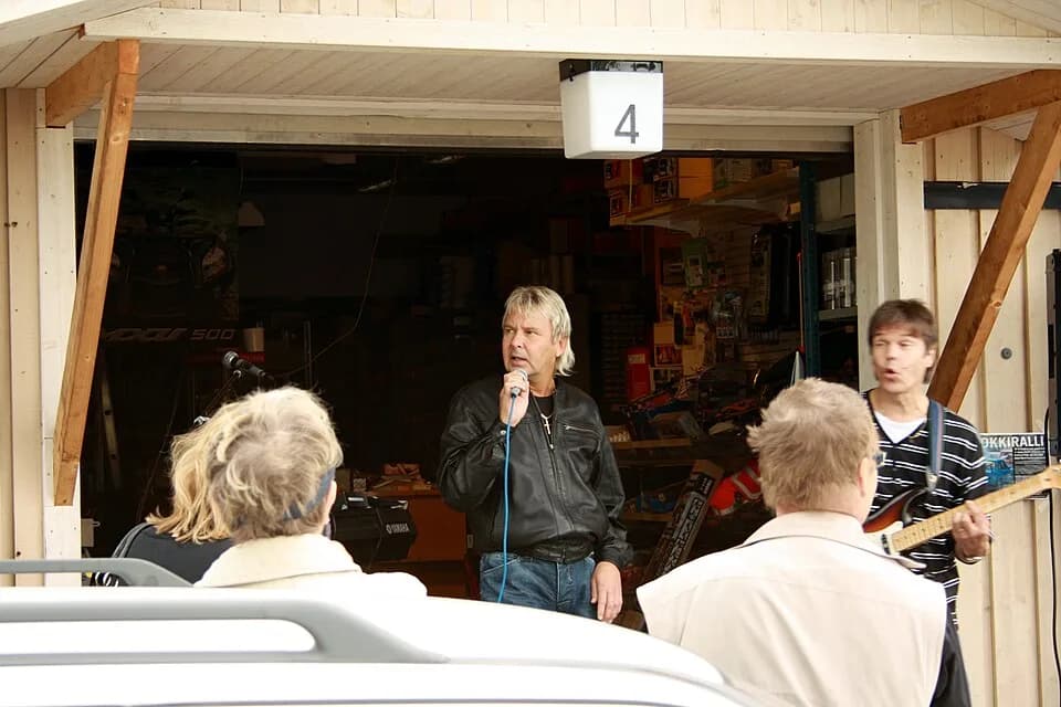 Matti Nykänen - Matti Nykänen singing and joking with his guitarist during a performance held at a car repair parts shop in Kirkkonummi, on the 19th of June 2010.