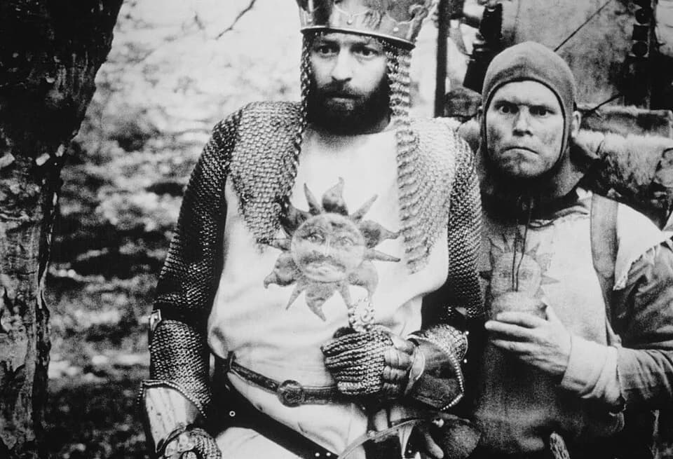 Graham Chapman - Actors Graham Chapman and Terry Gilliam as King Arthur and Patsy in a publicity photo of the 1975 film Monty Python and the Holy Grail, distributed in the US by Cinema 5.