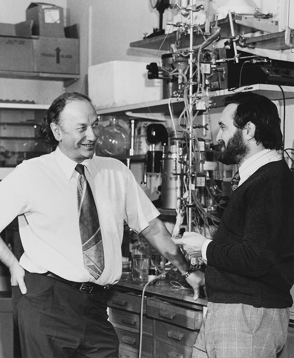 John Vane - Photograph of Sir John Vane (left) and Dr Salvador Moncada in a laboratory, with chemical apparatus in the background. Picture probably taken in the Wellcome Laboratories at Beckenham, Ken