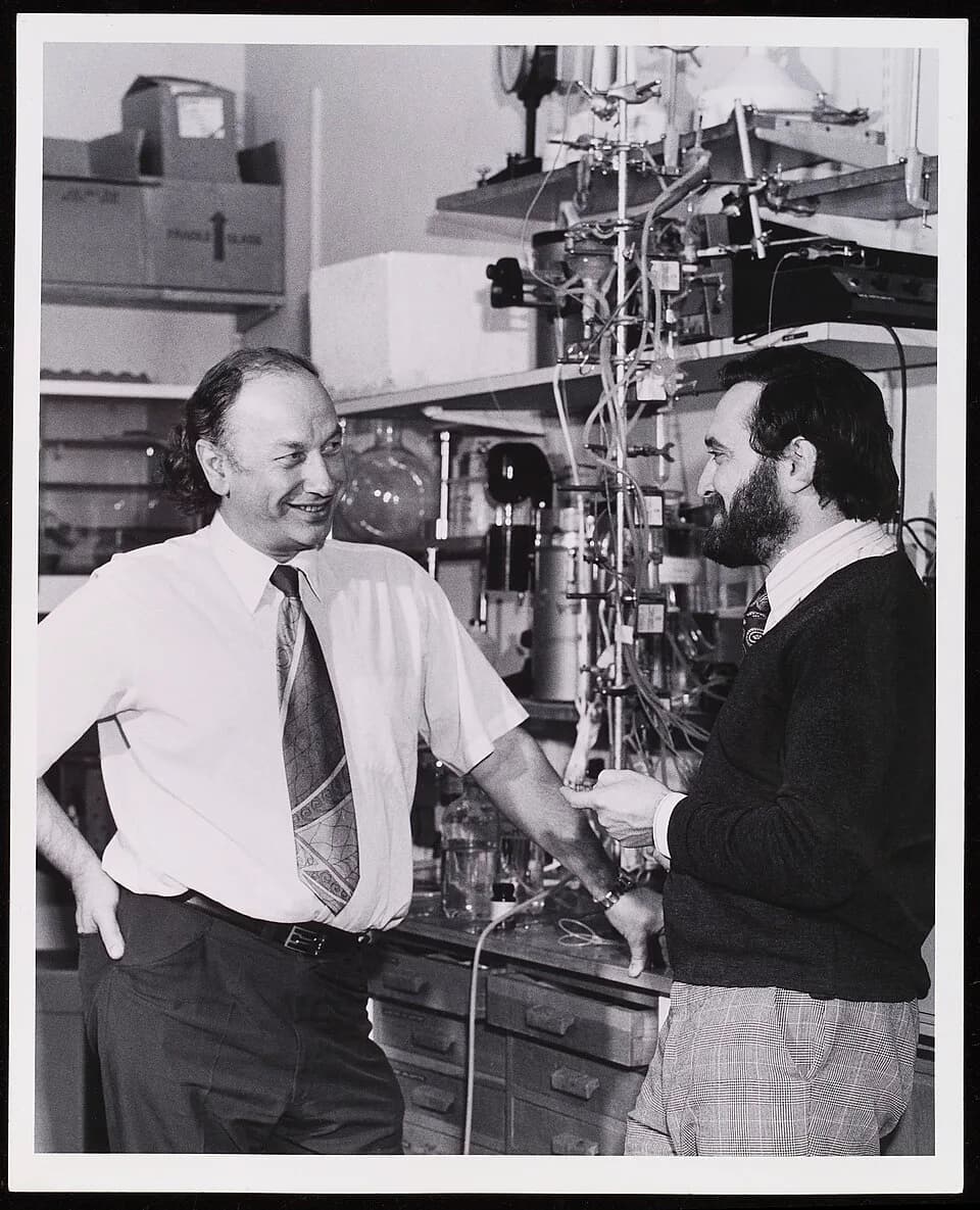 John Vane - Photograph of Sir John Vane (left) and Dr Salvador Moncada in a laboratory, with chemical apparatus in the background. Picture probably taken in the Wellcome Laboratories at Beckenham, Ken