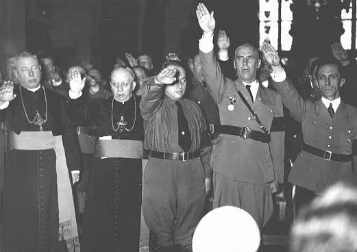 Joseph Goebbels - Catholic clergy and Nazi officials, including Joseph Goebbels (far right) and Wilhelm Frick (second from right), give the Nazi salute. Germany, date uncertain.
