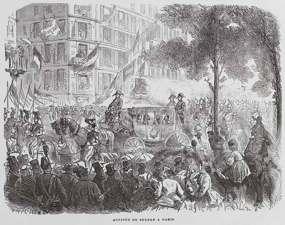 Abdülaziz - The Turkish Sultan arriving at the Paris World Fair, in 1867. On the image, the Sultan is sitting in the carriage, wearing a round hat and a grey scarf. Next to him is Napoléon III, who wa