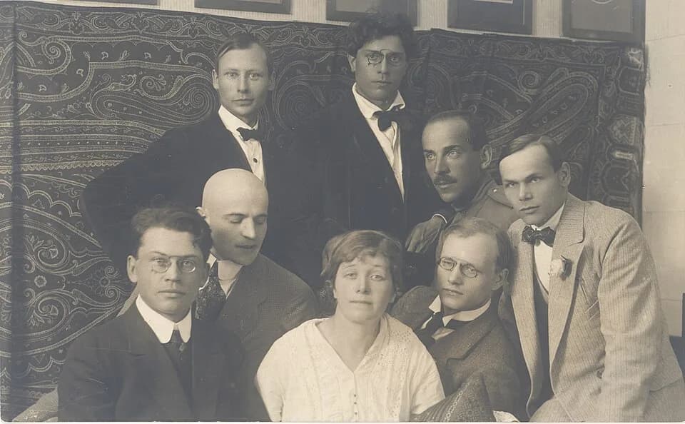 Marie Under - "Siuru".
Ülemises reas seisavad vasakult: kunstnikud 1) Peet Aren, 2) Otto Krusten

Alumises reas istuvad vasakult: 1) Friedebert Tuglas, 2) Arthur Adson, 3) Marie Under, 4) August Gaili