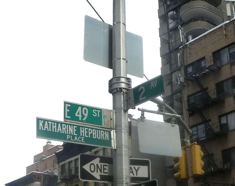 Katharine Hepburn - Looking east and up at street sign for Katharine Hepburn Way on a cloudy day.