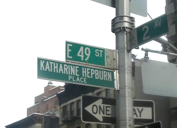 Katharine Hepburn - Looking east and up at street sign for Katharine Hepburn Place, Manhattan on a cloudy day.