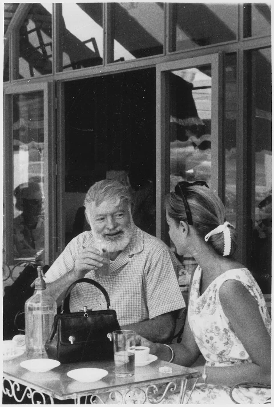 Lauren Bacall - Scope and content:  Photograph of Ernest Hemingway having drinks with Lauren Bacall in Spain.