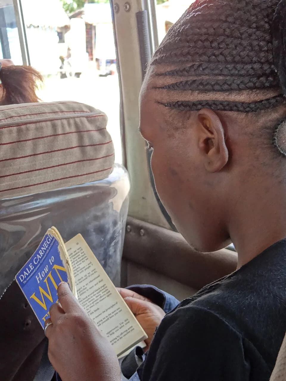 Dale Carnegie - Young African Woman Reads Dale Carnegie - How to Win Friends and Influence People - En route from Bagamoyo to Mwenge - Tanzania