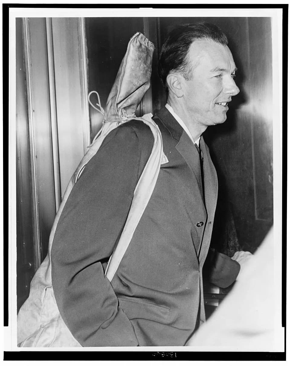 Pete Seeger - Pete Seeger arrives at Fed. Court with his guitar over his shoulder / World Telegram photo by Walter Albertin.