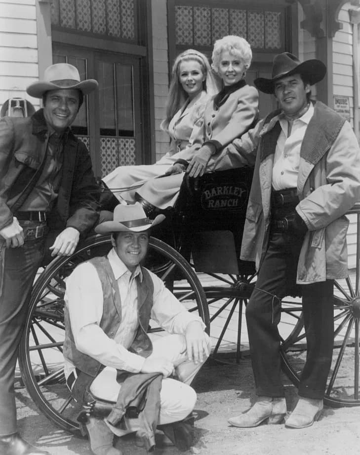 Barbara Stanwyck - Cast photo from the television Western The Big Valley. From left: Richard Long, Linda Evans, Barbara Stanwyck, Peter Breck, and Lee Majors by wagon wheel.