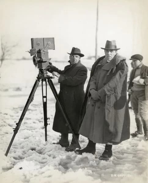 D. W. Griffith - Cameraman G. W. "Billy" Bitzer and director D. W. Griffith on location in the snow filming the American film Way Down East (Griffith, 1920). Bitzer stands behind a Pathé camera.