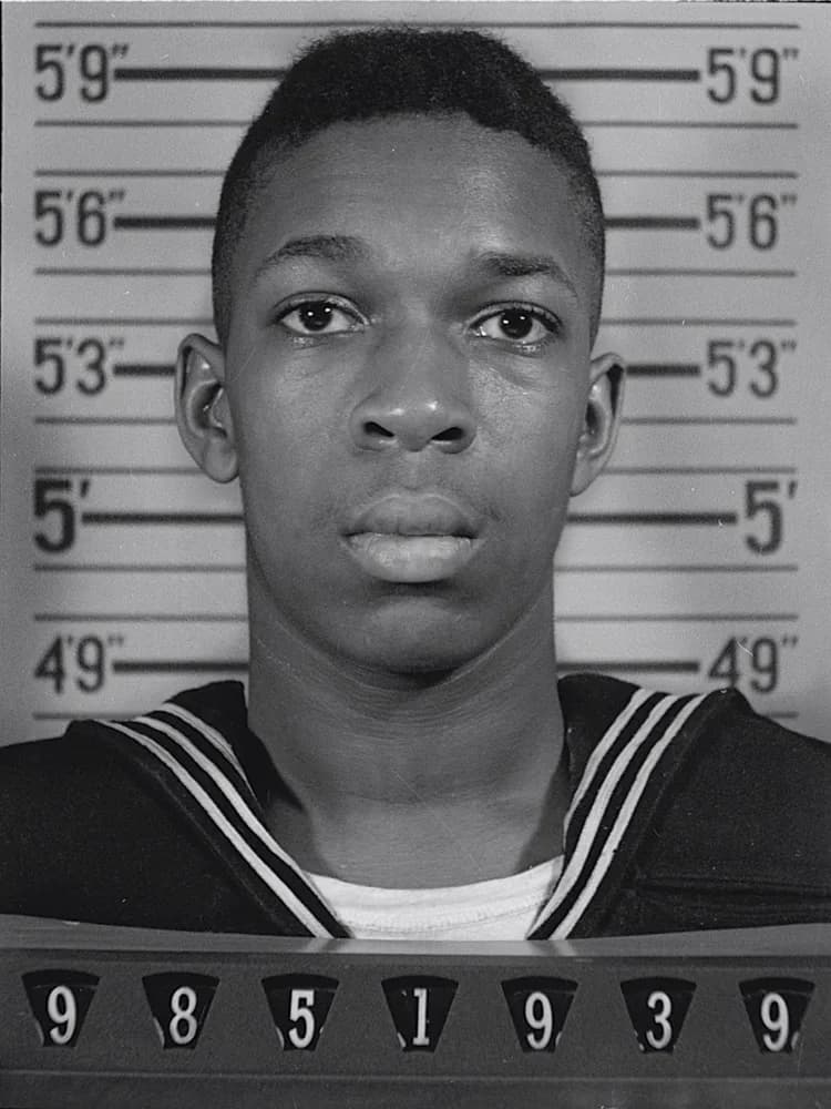 John Coltrane - United States Naval Reserve portrait of John Coltrane. While this may look like a mug shot, it is an actual official service photograph.