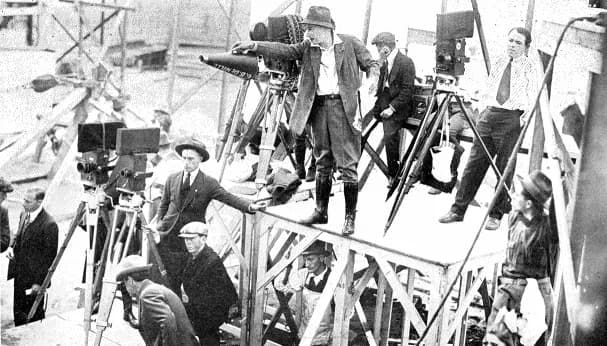 Cecil B. DeMille - Original caption: Cecil B. de Mille directing a scene with four Pathé professional cameras and a Bell and Howell trained on the set.