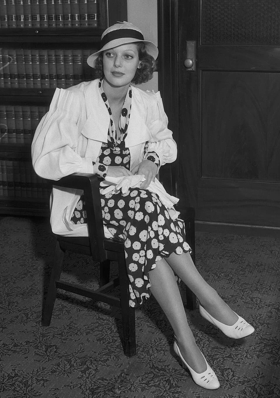 Loretta Young - Loretta Young sits in a chair in what appears to be an office.