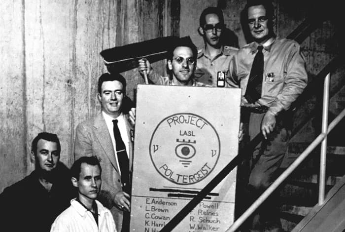 Frederick Reines - Group portrait of the “Project Poltergeist” team searching for the neutrino; Frederick Reines holds the poster, Clyde Cowan is at far right; ca 1953