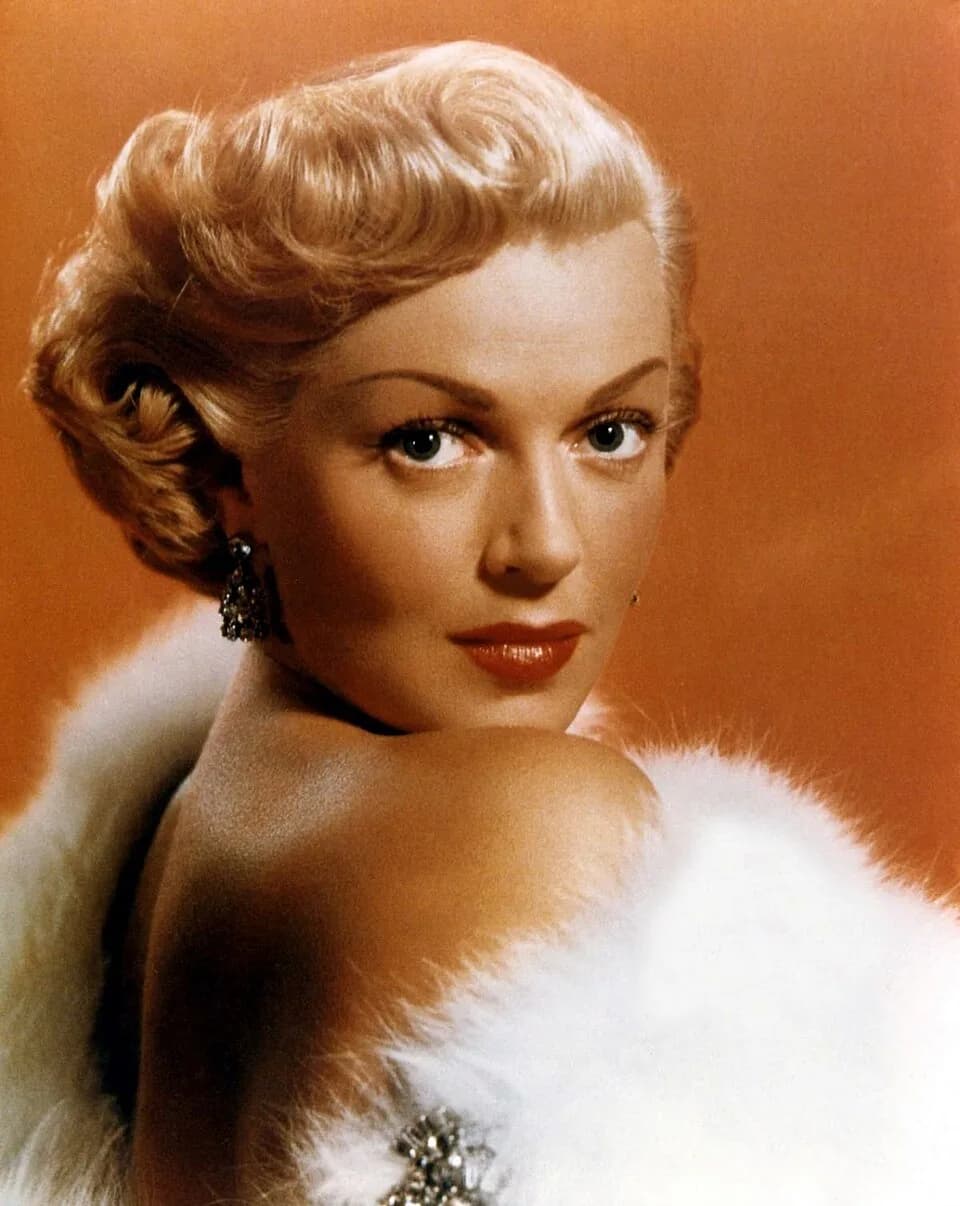Lana Turner - American actress Lana Turner wearing a white fur stole with a jewelled brooch