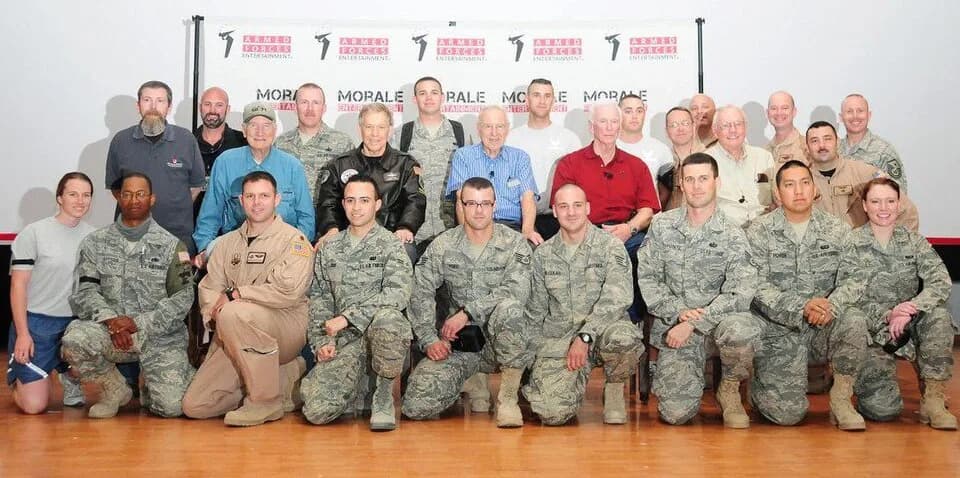 Jim Lovell - Neil Armstrong is in the middle row, second to the left (viewer's right), wearing the cream-colored shirt. Immediately to Armstrong's right is Eugene Cernan (red shirt), and immediately t