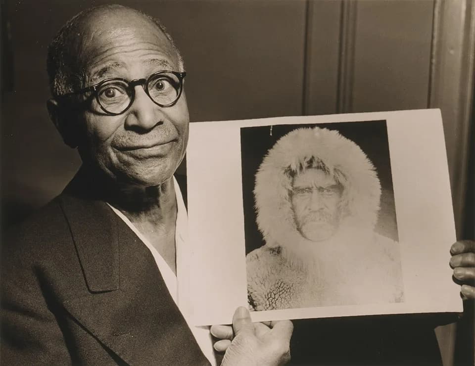 Robert Peary - Matthew Henson, head-and-shoulders portrait, facing front, holding a portrait of Robert E. Peary taken during an expedition to the North Pole / World-Telegram photo by Roger Higgins.