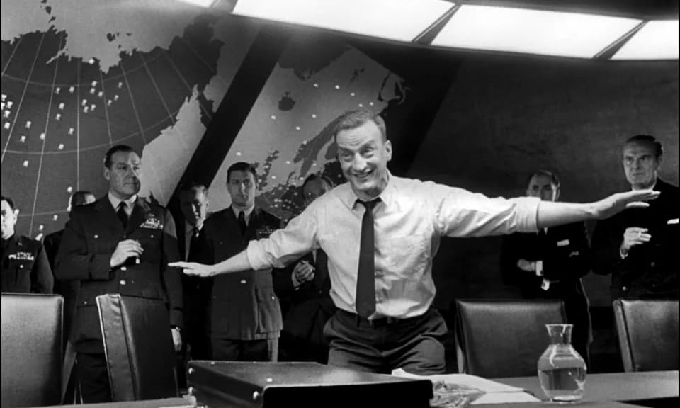 George C. Scott - General Buck Turgidson (George C. Scott) demonstrating a B-52 flying low enough to fry chickens in a barnyard.