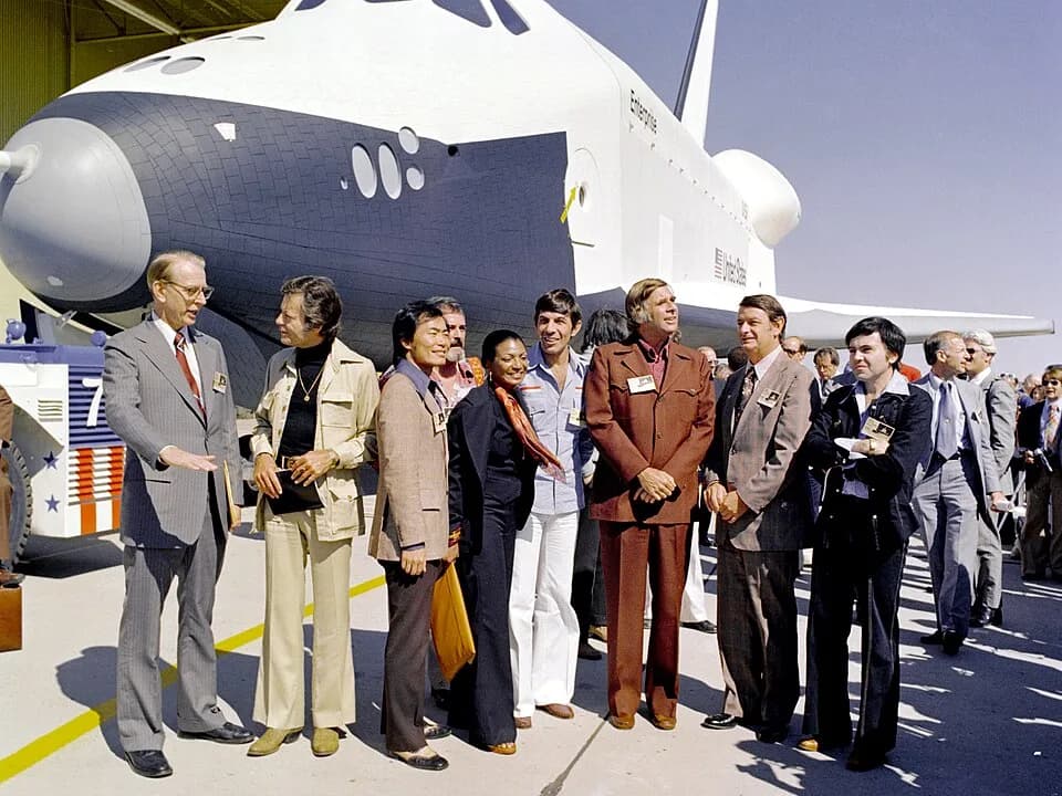 Gene Roddenberry - The Shuttle Enterprise rolls out of the Palmdale manufacturing facilities with Star Trek television cast members. From left to right they are: Dr. James C. Fletcher (NASA Administra