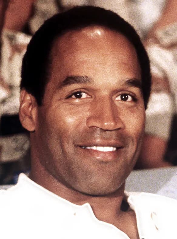 O. J. Simpson - NBC Sports commentator and former professional football player O. J. Simpson sits with a group of servicemen to watch a Thanksgiving Day football game. Simpson is visiting U.S. troops 
