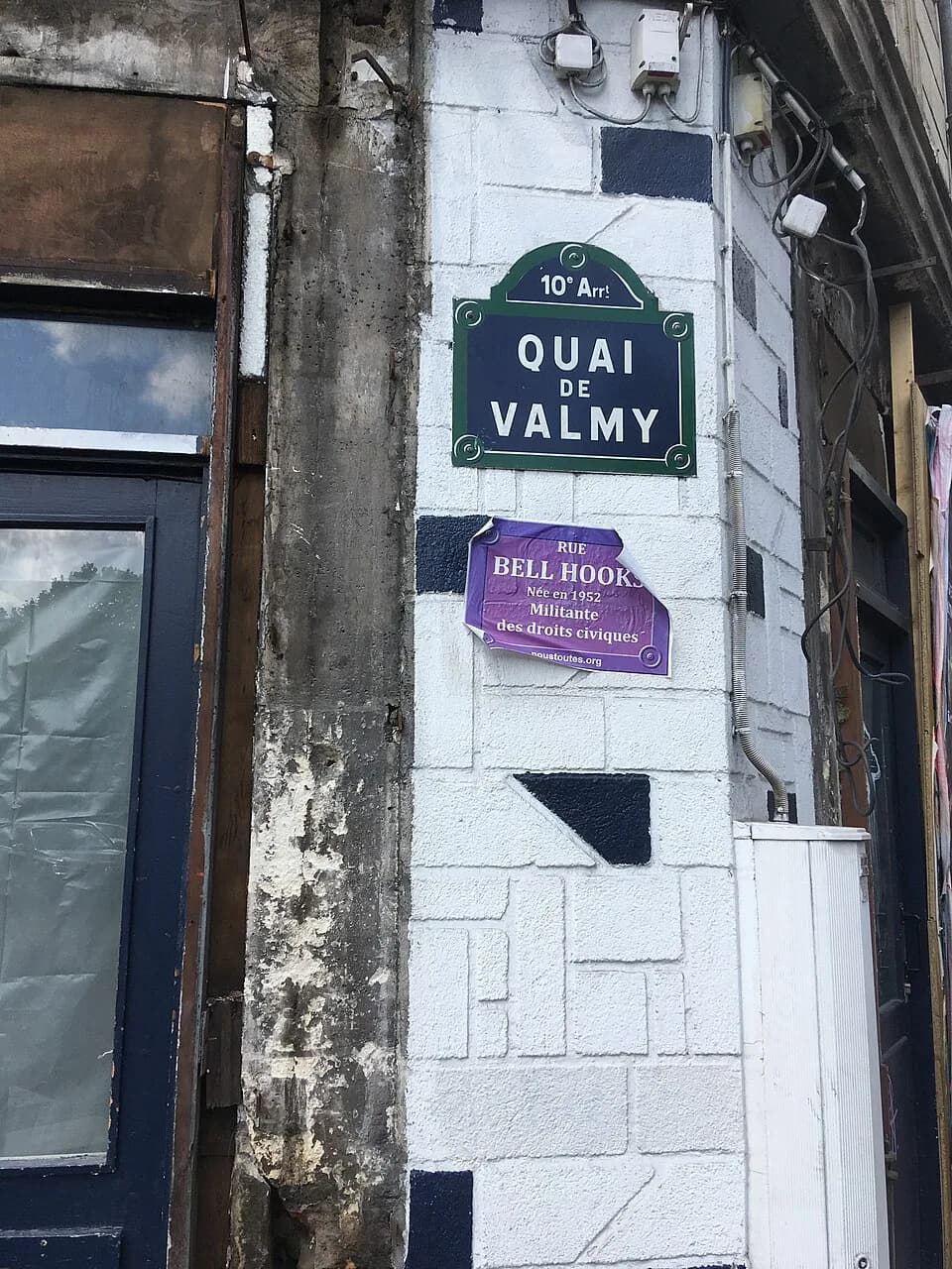 bell hooks - Plaque du quai de Valmy (Paris) avec une fausse plaque de rue bell hooks collée en dessous par le collectif #NousToutes