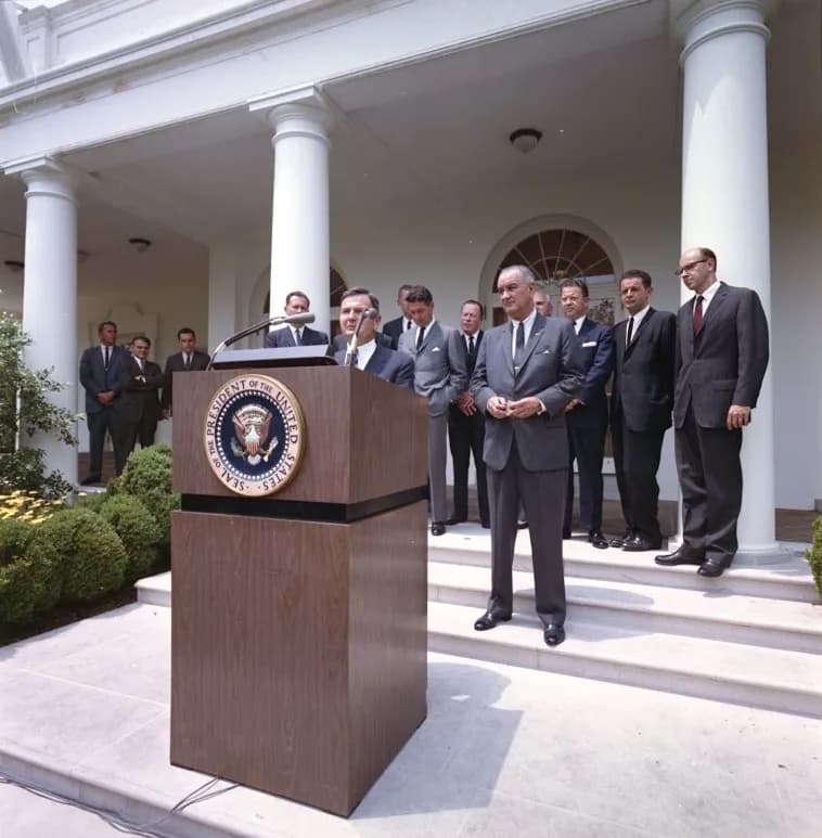 David Rockefeller - In this photo, David Rockefeller takes the podium as President Lyndon Johnson looks on in the White House Rose Garden on 15 June 1964 to announce the launch of the International Ex