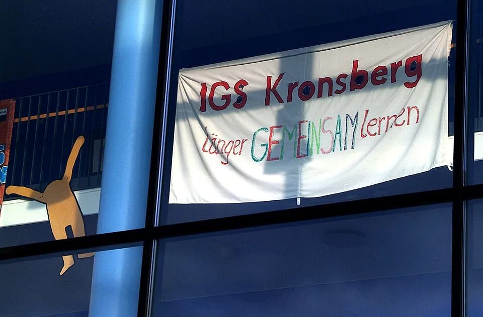 Keith Haring - "Länger GEMEINSAM lernen" signalisiert dieses Stoff-Transparent der hinter der Glasfassade am Haupteingang der Integrierten Gesamtschule Kronsberg; die im Bild unten rechts zu sehende F