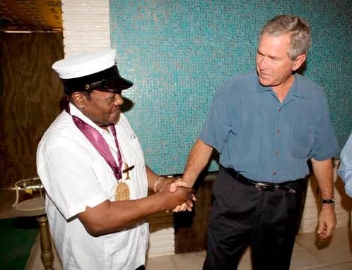 Fats Domino - President George W. Bush shakes the hand of legendary Fats Domino. Domino is wearing a New Orleans brass band musician's cap on his head and a National Medal of Arts around his neck.  Th