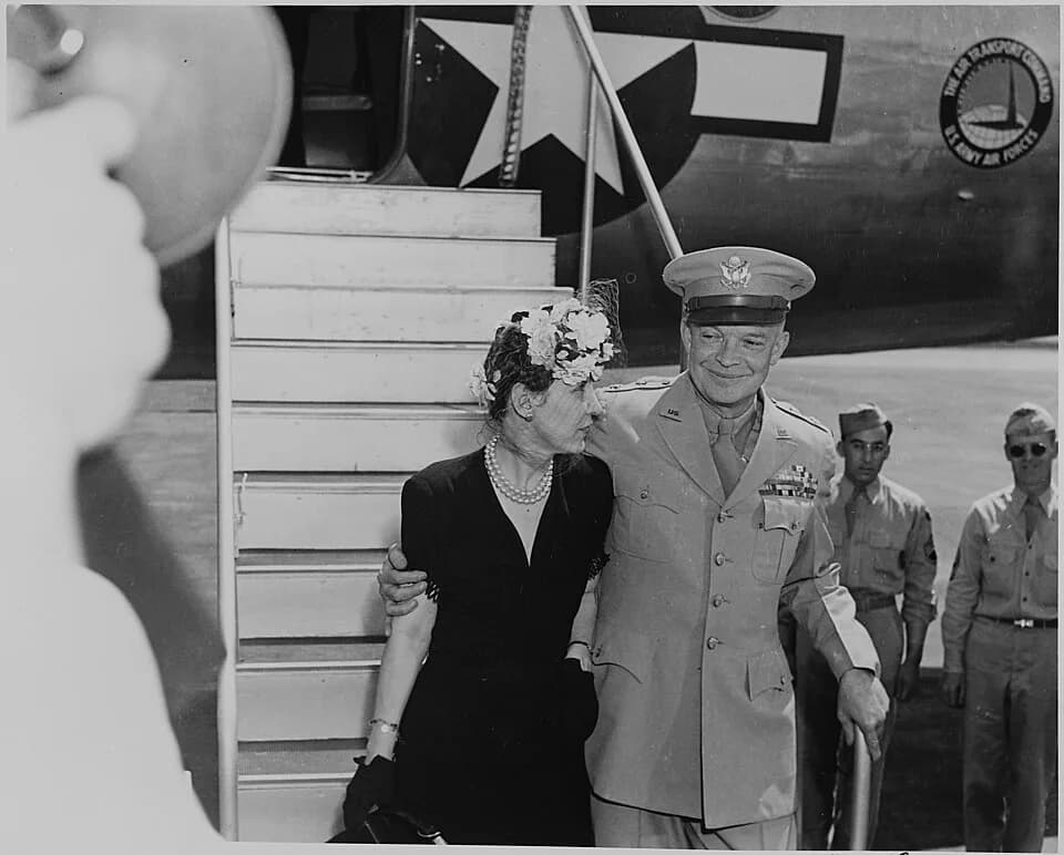 Mamie Eisenhower - General Dwight D. and Mamie Eisenhower descending an airplane ramp, on route to a White House ceremony in which... - NARA - 199106.jpg