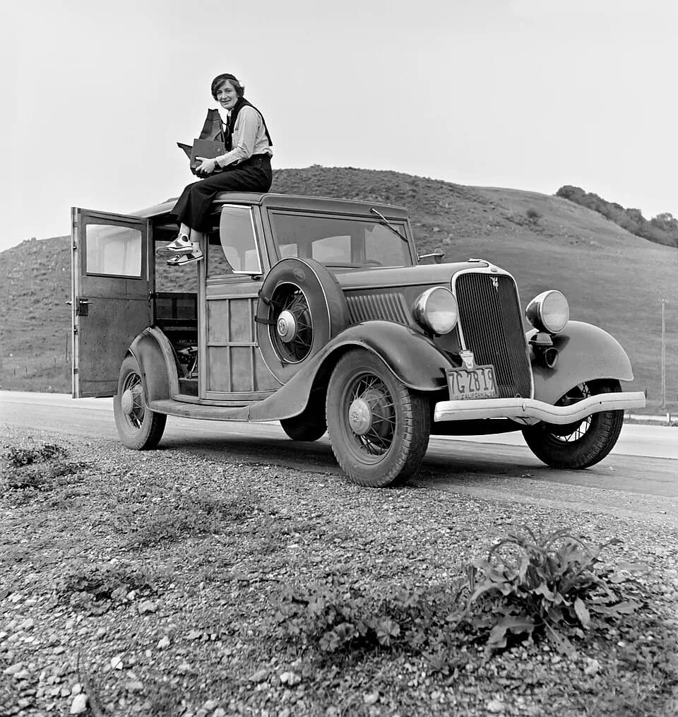 Dorothea Lange - Dorothea Lange atop automobile in California. 
The car is a 1933 Ford Model C, 4 door Wagon.  The camera is a Graflex 5x7 Series D.
Lange was a New Deal Resettlement Administration an