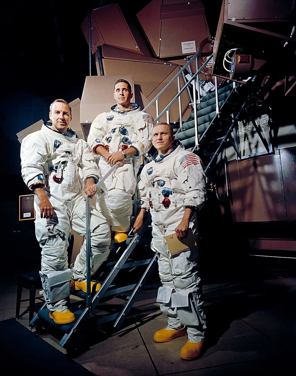 Bill Anders - Apollo 8 crew is photographed posing on a Kennedy Space Center (KSC) simulator in their space suits. From left to right are: James A. Lovell Jr. (1928–2025), William A. Anders (1933–2024