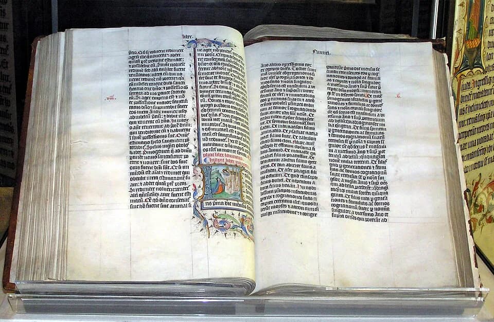 Rudolf Bultmann - A Bible handwritten in Latin, on display in Malmesbury Abbey, Wiltshire, England. This Bible was written in Belgium in 1407 AD, for reading aloud in a monastery.