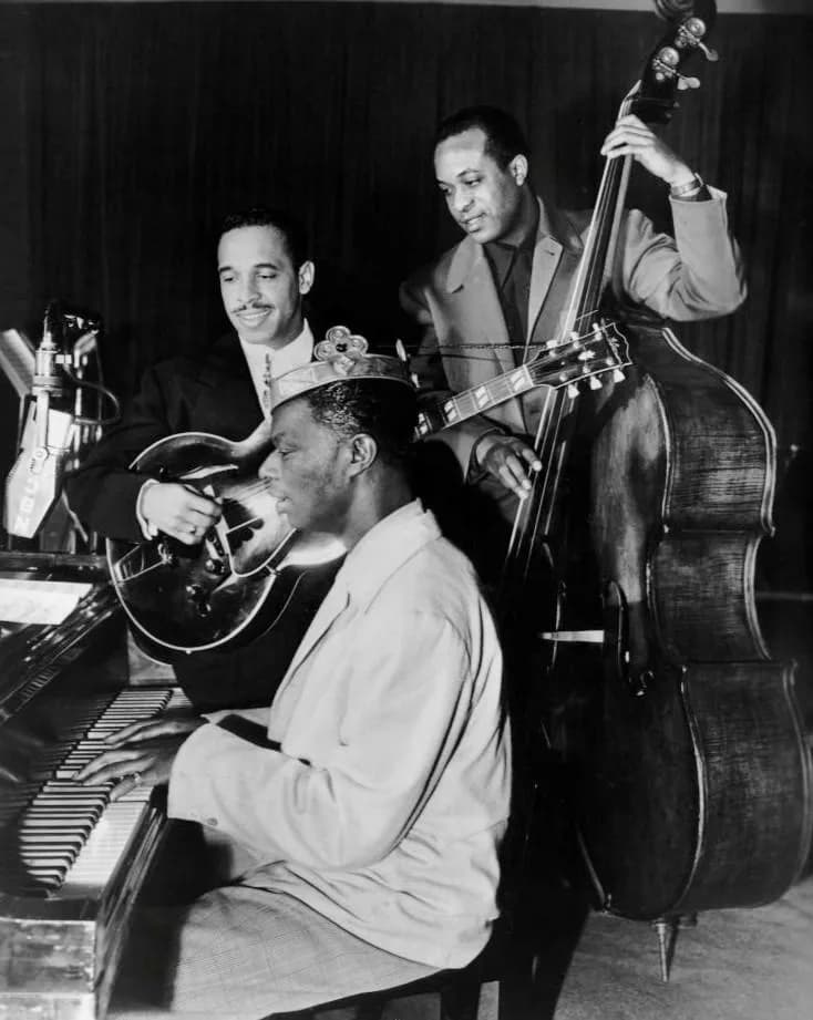 Nat King Cole - Photo of the Nat King Cole Trio from the radio program King Cole Trio Time.  Nat King Cole at the piano, Oscar Moore on guitar, and Johnny Miller on bass. The program aired on NBC Radi