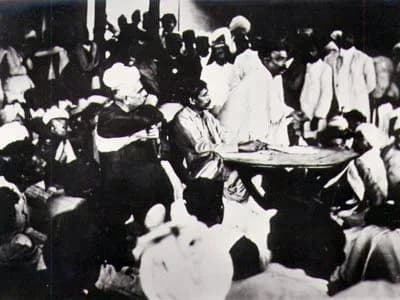 Aurobindo Ghosh - Indian nationalist leader Bal Gangadhar Tilak speaking at the Surat Congress. Seated with his hands on the table is Sri Aurobindo (1872-1950) and to his right (seated in a chair) is