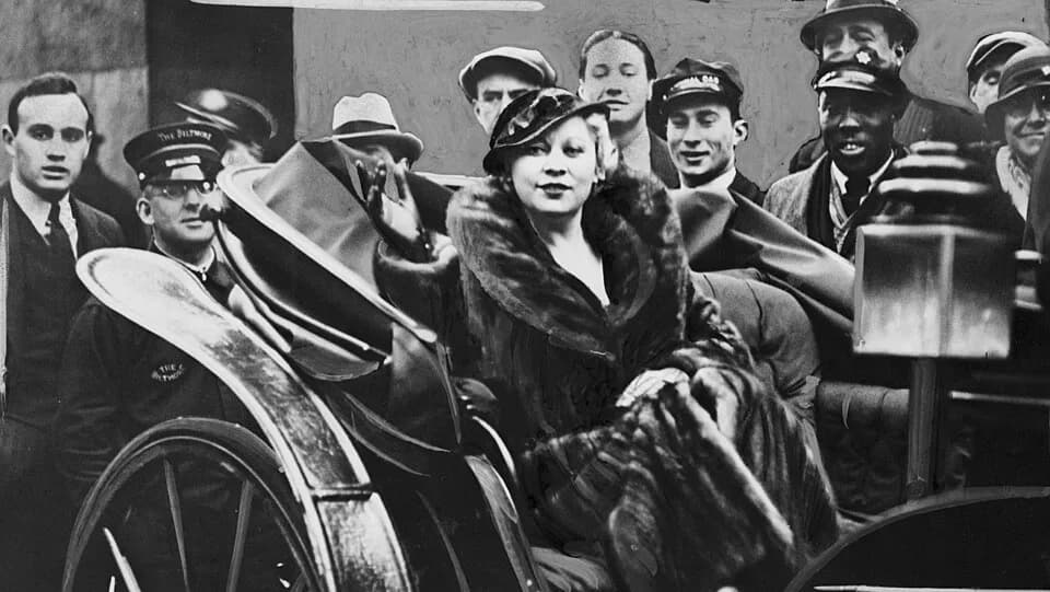 Mae West - Mae West. Library of Congress description: "Diamond L'il rides home from Hollywood... / World Telegram photo. Mae West, riding in a carriage, on her return from Hollywood."