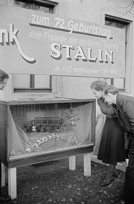 Joseph Stalin - Original image description from the Deutsche FotothekModell eines mehrscharigen Pflugs, hergestellt von der
Jugendgruppe der FDJ in der Lehrwerkstatt des VEB Land-,
Bau- und Holzbearbe