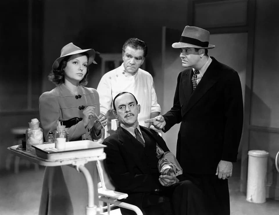 Boris Karloff - L. to R. : Marjorie Reynolds, Boris Karloff (seated), Raymond Hatton, and Grant Withers in Doomed to Die (1940) - cropped screenshot