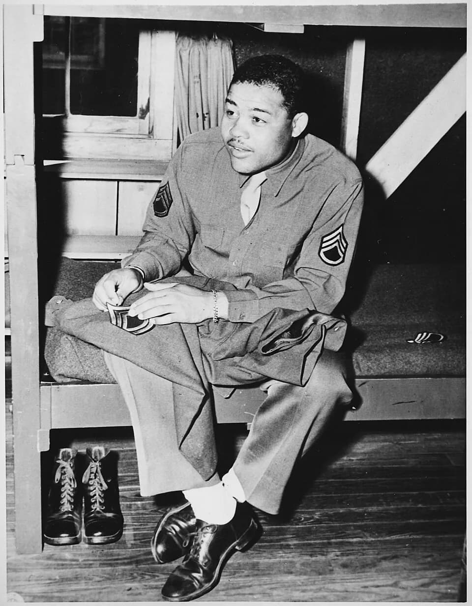 Joe Louis - "World Heavyweight champ Joe Louis (Barrow) sews on the stripes of a technical sergeant-to which he has been promoted. - NARA - 535937.jpg