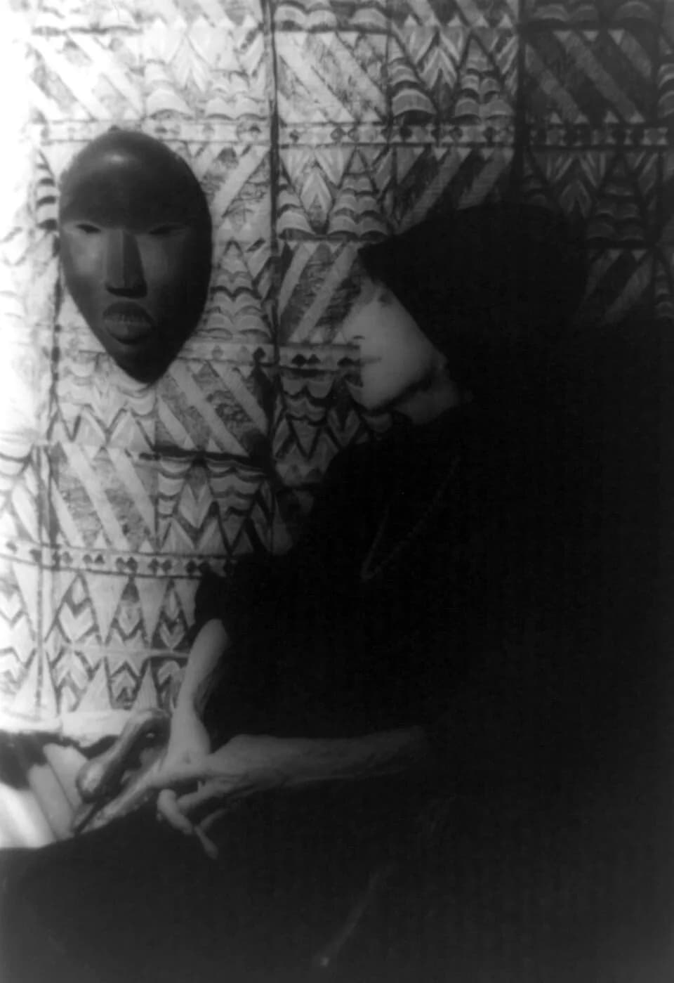 Karen Blixen - Portrait of Isak Dinesen (Baroness Karen Blixen) looking at African mask and textile on wall, 1959 Jan. 29.