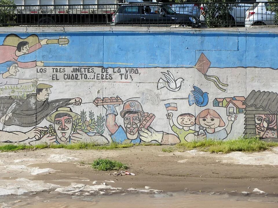 Violeta Parra - 100 años del Partido Comunista de Chile, homenaje de los grafiteros del PC, ribera norte del río Mapocho, 2012. A la izquierda, volando, Víctor Jara, Violeta Parra y Pablo Neruda.