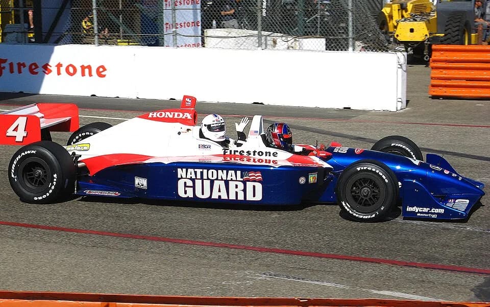 Huell Howser - Huell Howser rides as a passenger in a 2-seat Indy Racing League open-wheel race car at the 2009 Long beach Gran Prix.