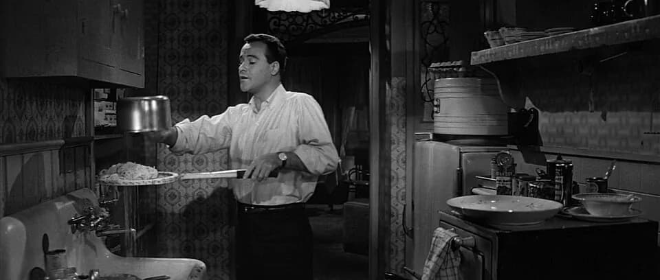 Jack Lemmon - Screenshot of Jack Lemmon as C.C. Baxter using a tennis racket to strain spaghetti in the trailer for the film The Apartment (1960)