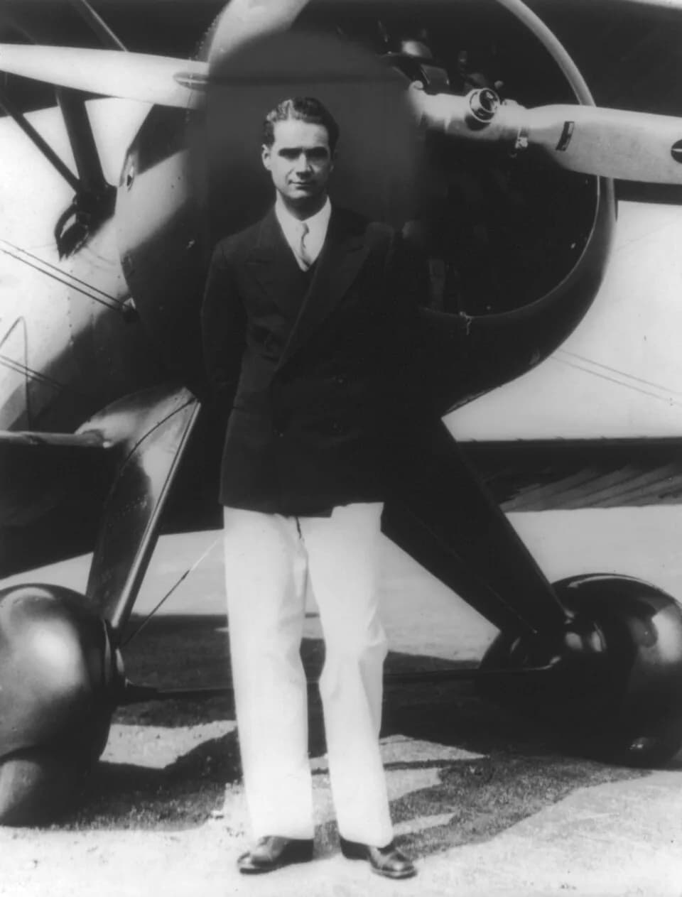 Howard Hughes - Howard Hughes "standing in front of his new Boeing Army Pursuit Plane" (Boeing 100A) in Inglewood, California in the 1940s.
The black "halo" is presumably intended to make the head sta
