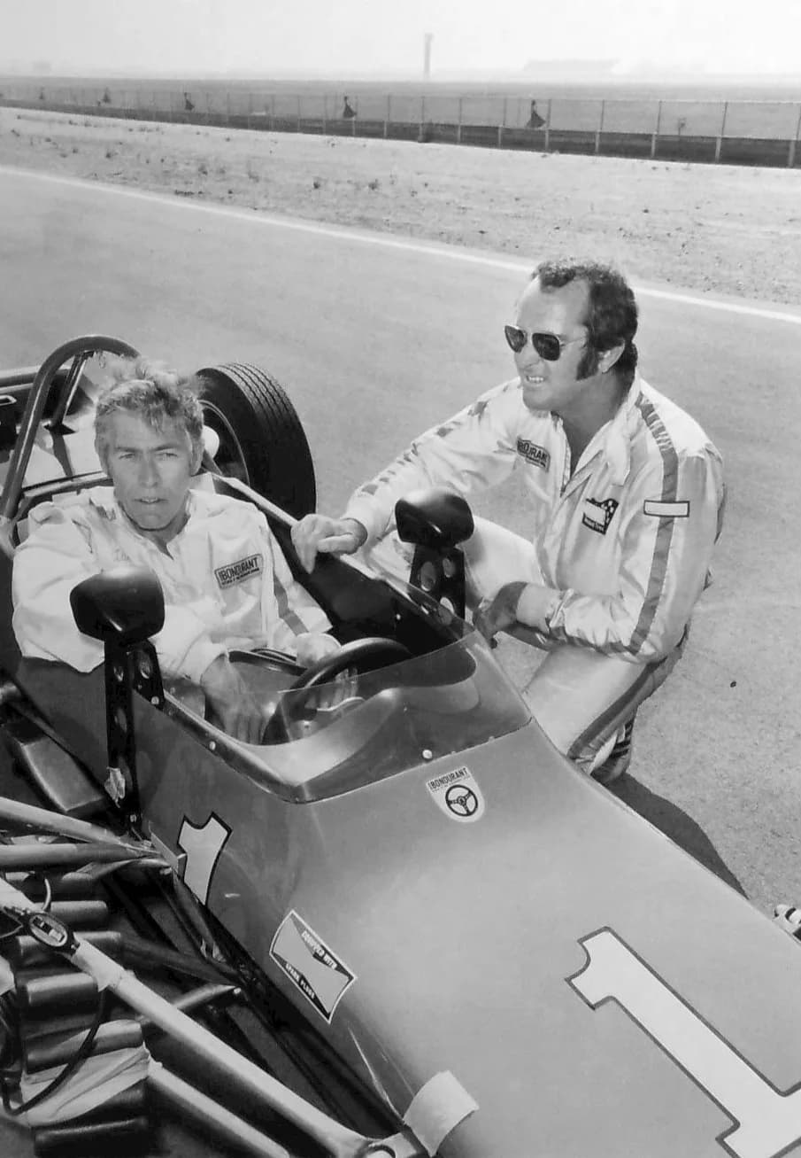 James Coburn - Photo of actor James Coburn being taught how to drive a racing car by Bob Bondurant. This was part of an ABC sports series called Challenge.