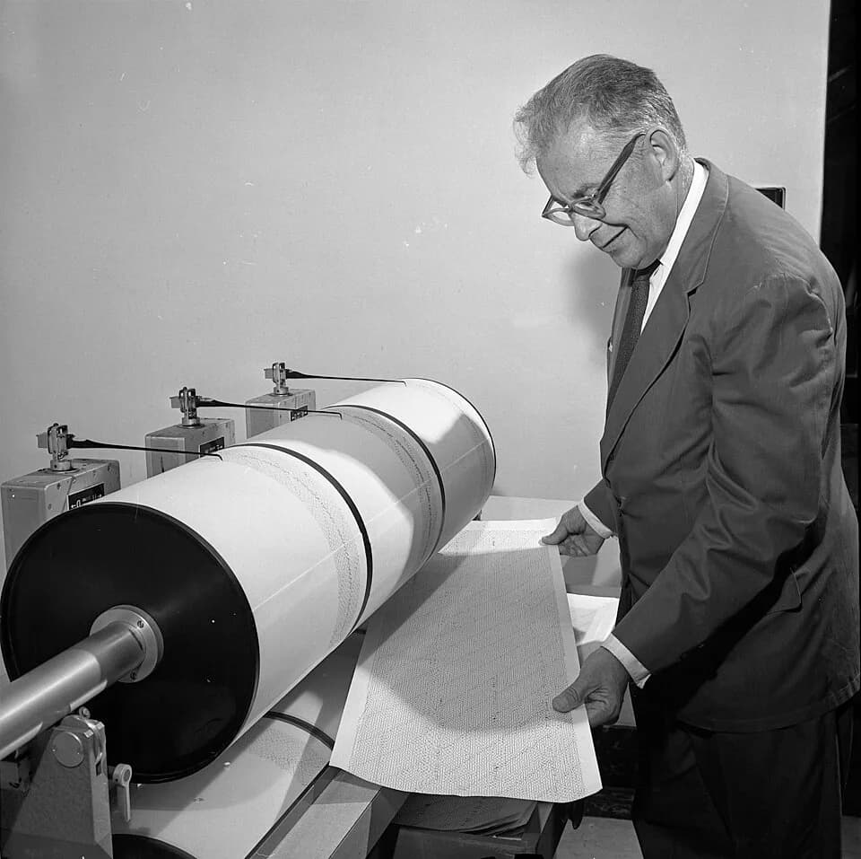 Charles Francis Richter - QUIVERINGS—Dr. Charles Richter, one of the world's leading earthquake experts, studies seismograph log upon which earth movements are recorded. He devised the Richter Scale t